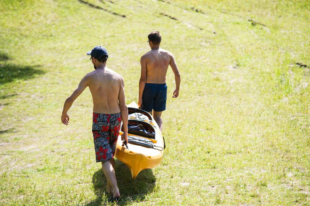 Two men carrying the kayak